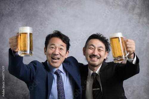 生ビールで乾杯するサラリーマンのカメラ目線　忘年会や新年会 イエ～～イ！！　上にコピースペースあり photo