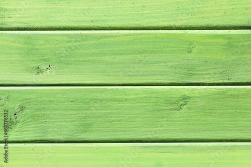 Horizontal green wood background. Green paint wood texture. Vibrant color plank. Lime color impregnated wood pattern. Bright backdrop. Outdoor woden long stripes. Natural lines pattern.
