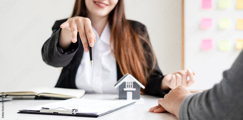 real estate agent with House model is talking to clients about buying home insurance. Home insurance concept real estate agent with House model is talking to clients about buying home insurance. Home insurance concept