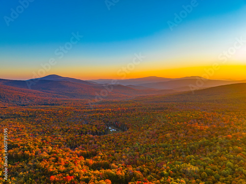 landscape of autumn mountain forest and mountain range in mist