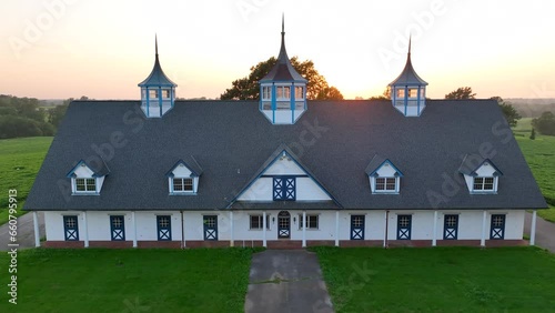 Aerial view of stables and barn at a horse farm in Lexington, Kentucky. Aerial establishing shot of picturesque scene during sunset in horse country. photo