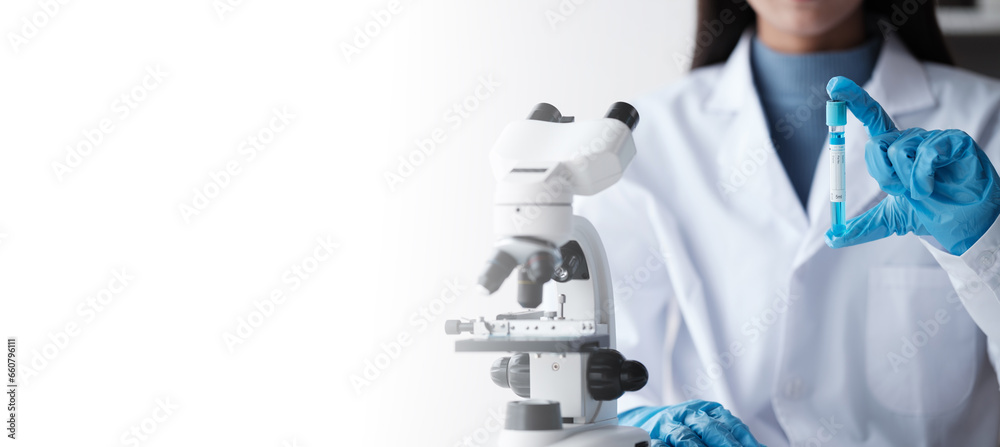 Scientist in a laboratory microscope with microscope slide in hand