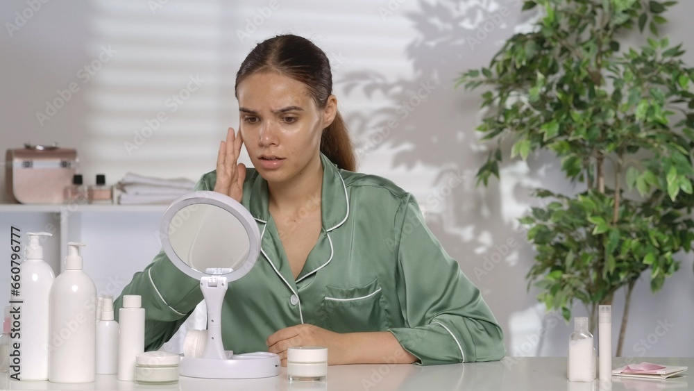 Portrait of a frustrated woman at her dressing table in front of a mirror. The disappointed woman is suffering because of her problem skin. Portrait of a frustrated woman at her dressing table in front of a mirror. The disappointed woman is suffering because of her problem skin.