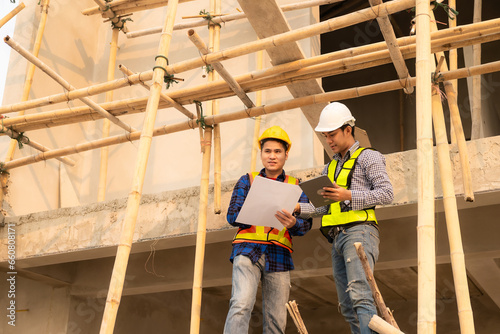 Co-workers discussing architecture projects at construction site at table Architects work with Engineer inspects site for construction project draft, architectural plan