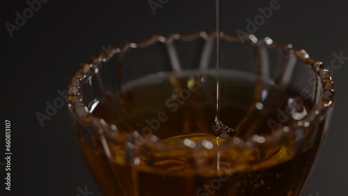 scooping honey from a glass cup