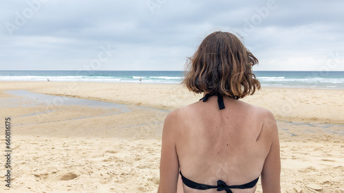 woman tourist from behind on the beach facing the sea ocean