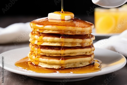 stack of fluffy pancakes with a drizzle of syrup © altitudevisual