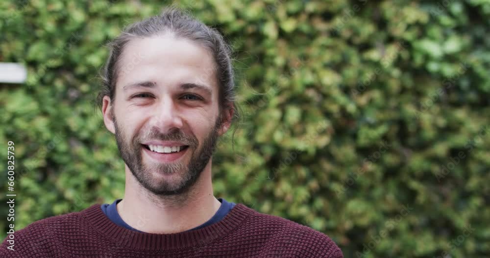 Portrait of happy caucasian man wearing red jumper in garden, slow motion Portrait of happy caucasian man wearing red jumper in garden, slow motion