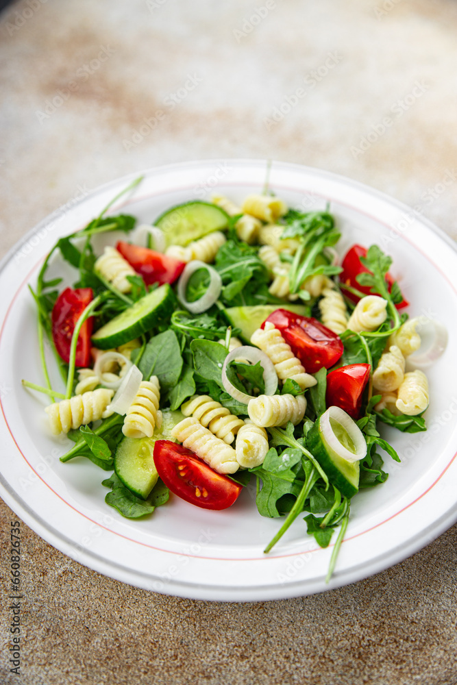pasta salad fusilli pasta, cucumber, tomato, green lettuce, onion healthy eating cooking appetizer meal food snack on the table copy space food background rustic top view