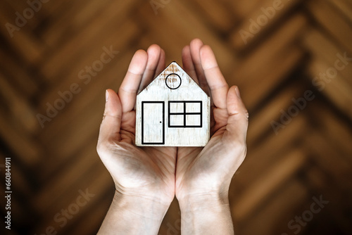 House in hands. Real estate, rent, purchase, sale, insurance concept. Model of a wooden house in the hands of the owner