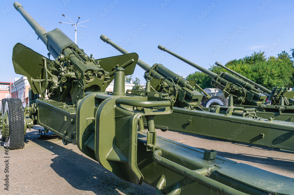 An artillery piece. Weapons of the army. The barrel of the cannon.  Towed artillery piece on wheels. A large caliber cannon for dealing damage at a great distance during combat operations.