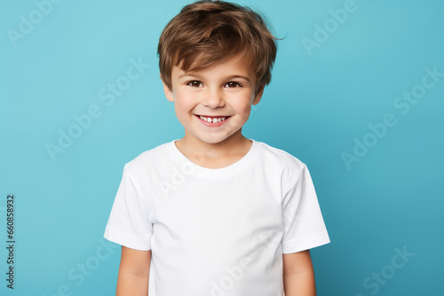 Young cute boy in a white T-shirt, mock-up. Empty white T-shirt for advertising in a studio.