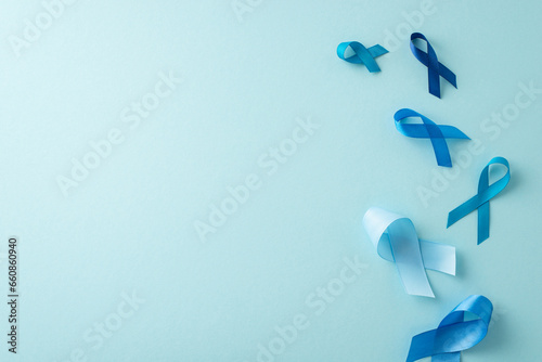 Men's health awareness visual. Overhead shot of flow of prostate cancer emblems - blue ribbons on a pastel blue surface with space for text or advertisements © ActionGP
