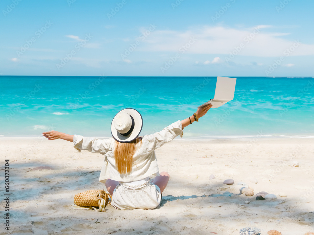 young woman uses laptop computer on the beach. distance work, freelancer and blogger concept. WiFi unlimited