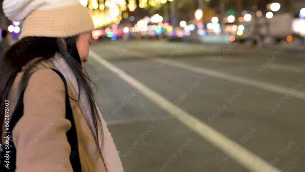 Beautiful woman holding hand in the street with christmas lights. Cheerful lady with warm hat looking at camera in winter. Beautiful woman holding hand in the street with christmas lights. Cheerful lady with warm hat looking at camera in winter.