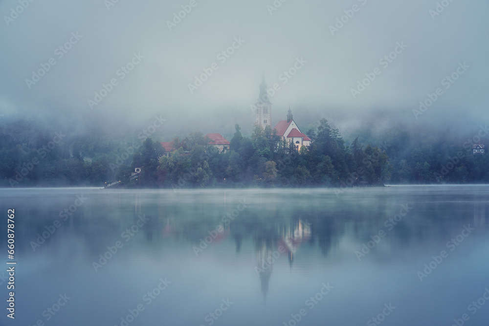 Φωτογραφία Famous alpine Bled lake (Blejsko jezero) in dense fog, amazing misty landscape, Slovenia