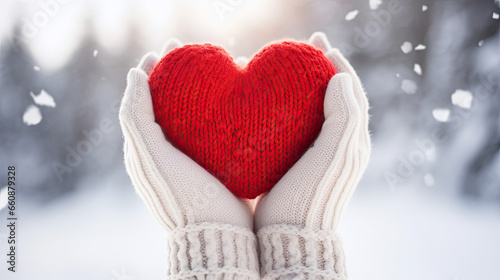 girl in gloves   holding a knitted heart in her hands  winter theme
