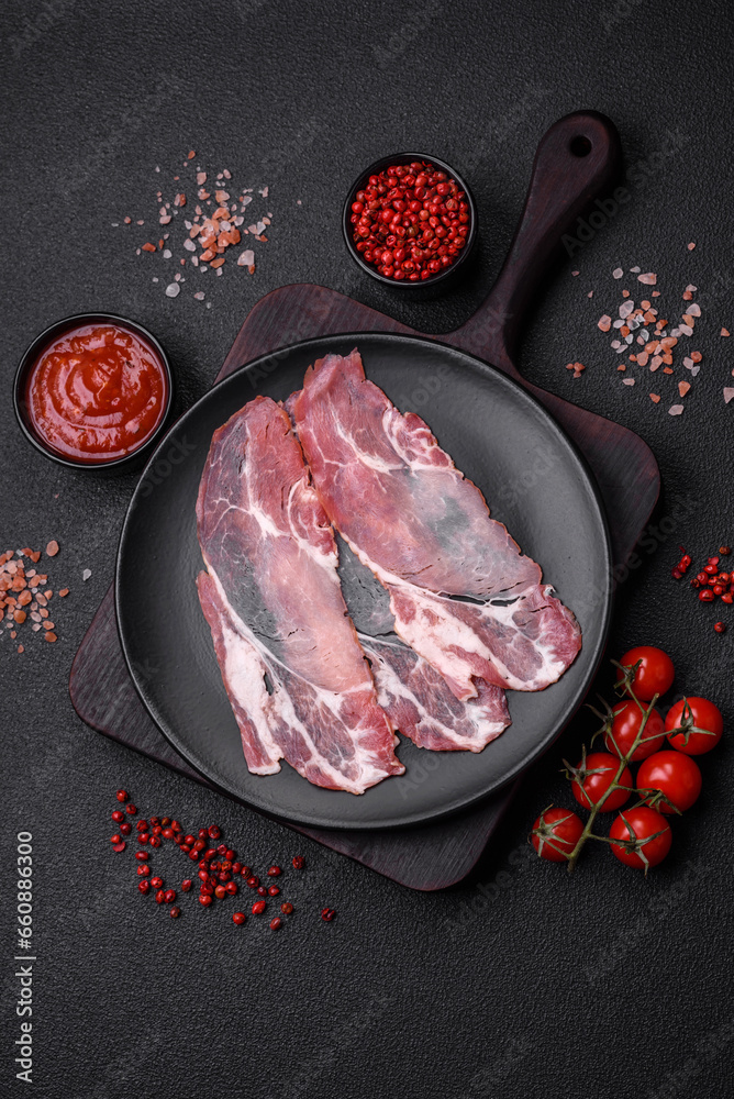 Slices of delicious smoked jamon or prosciutto with salt, spices and herbs