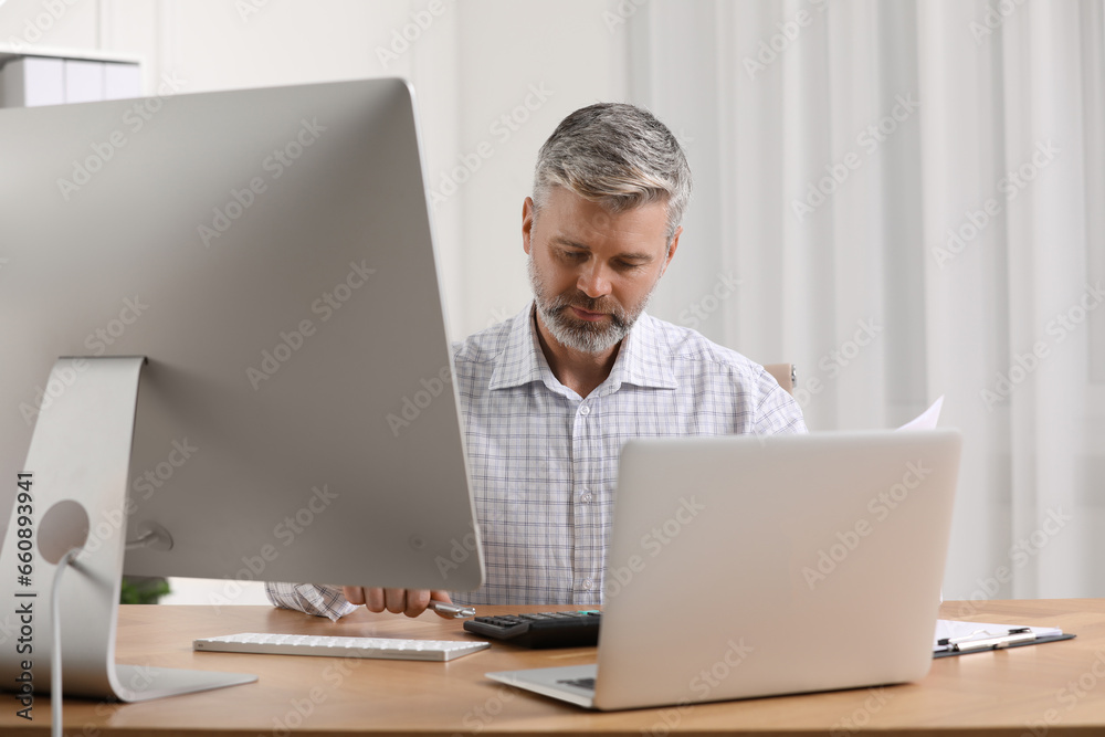 Professional accountant working at wooden desk in office Professional accountant working at wooden desk in office