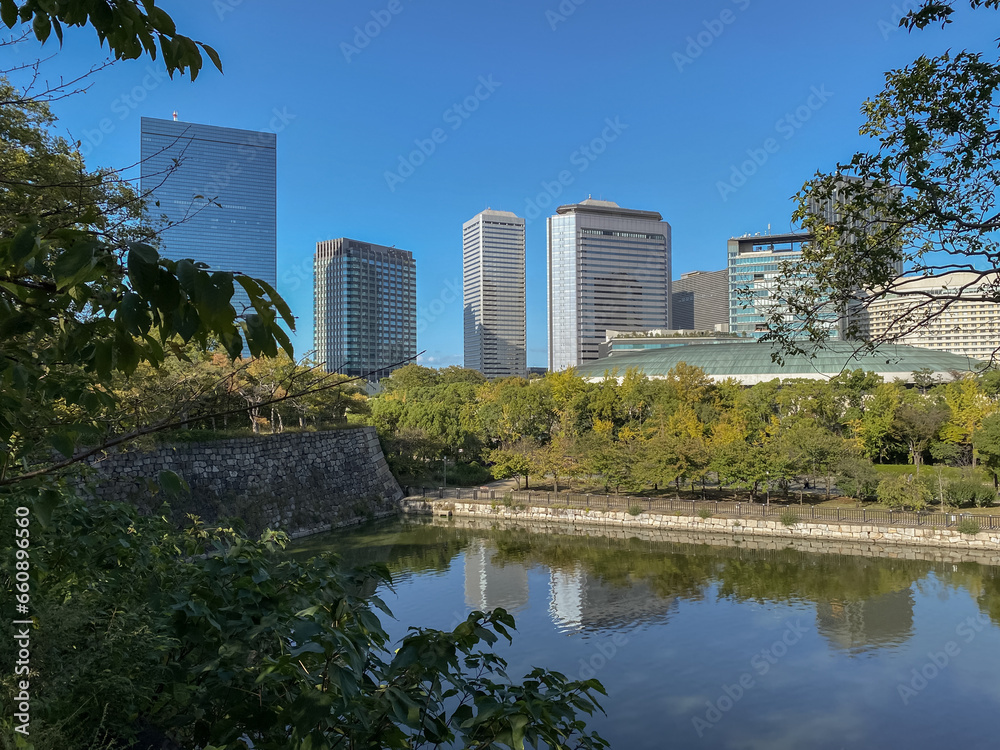 Promenade and trails inside public park in Japanese city of Osaka with modern architecture skyline cityscape view and historic fortress nature landscape scenery lots of trees, plants and bushes autumn Promenade and trails inside public park in Japanese city of Osaka with modern architecture skyline cityscape view and historic fortress nature landscape scenery lots of trees, plants and bushes autumn