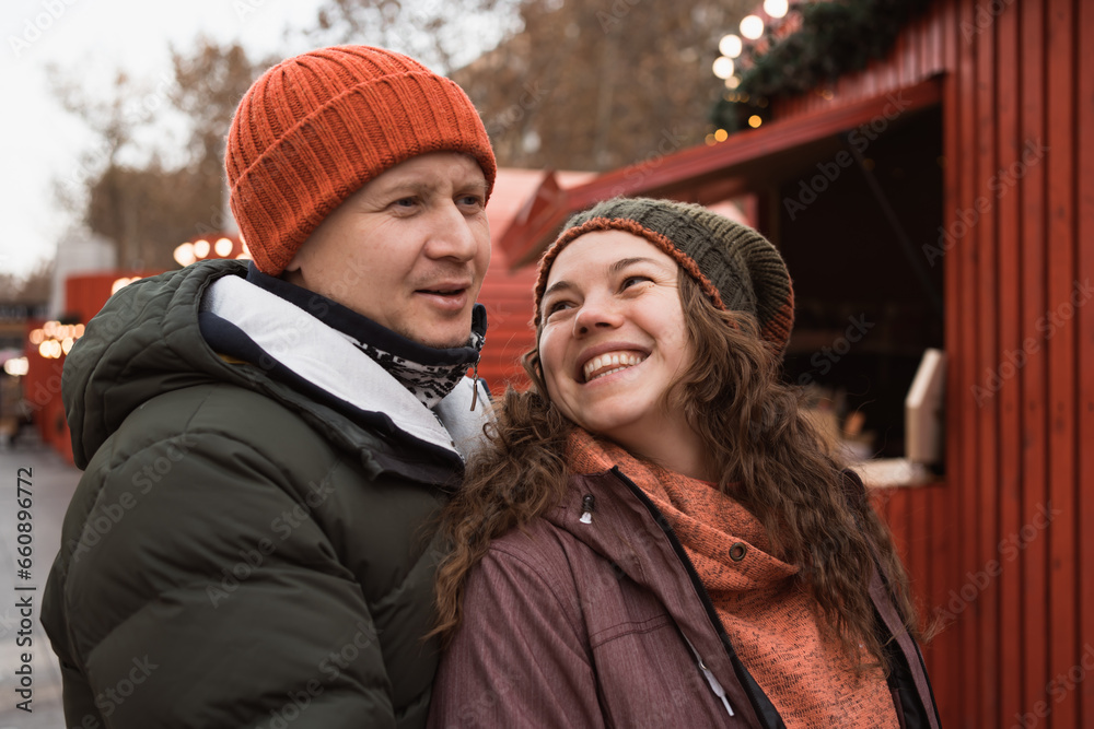Happy adult couple in love visiting christmas market in holidays Happy adult couple in love visiting christmas market in holidays