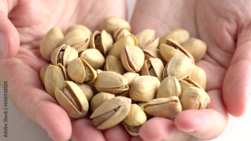Woman holding pistachio nuts in hand, closeup. Organic snack