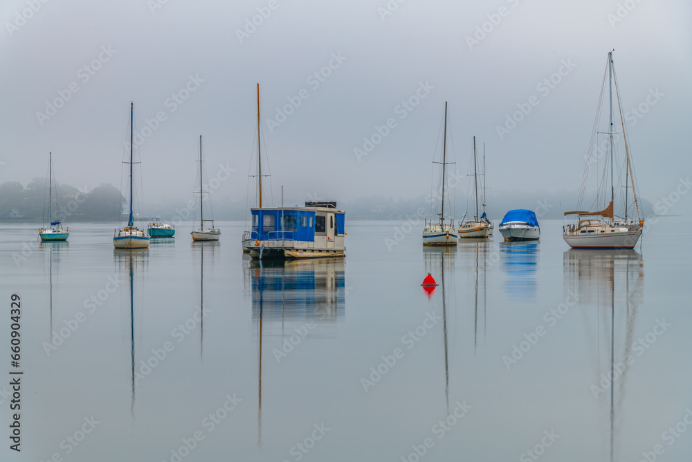 Fog, sunrise and boats on the bay