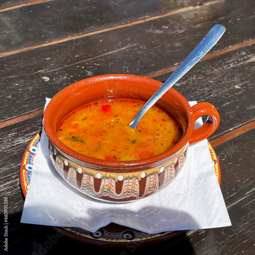 Bowl of traditional Bulgarian bean soup on a garden table photo