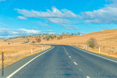 Road trippin through the dry countryside under a blue sky with clouds