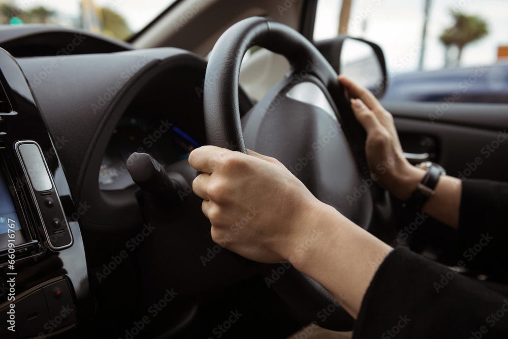 Driving a car photo background. Steering wheel and hands of a driver, city car interior