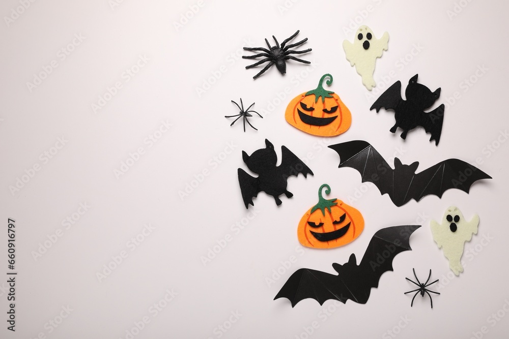 Flat lay composition with bats, pumpkins, ghosts and spiders on white background, space for text. Halloween celebration