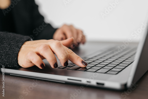 Close-up of remote work in a modern office. The woman's hands press "Enter" upon completion of the work. The concept of Internet resources and modern technologies.