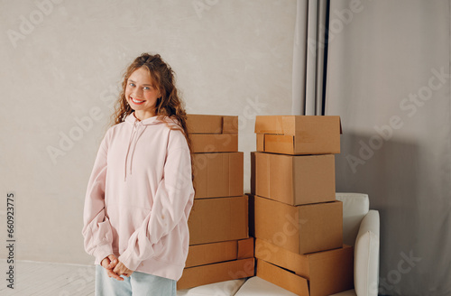 Happy young woman portrait moving with cardboard boxes to new estate home apartment © primipil