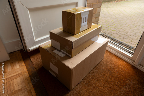 Delivery of parcels on doormat of domestic house. All labels are illegible or dummies.
