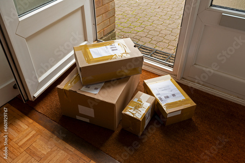 Delivery of parcels on doormat of domestic house. All labels are illegible or dummies.