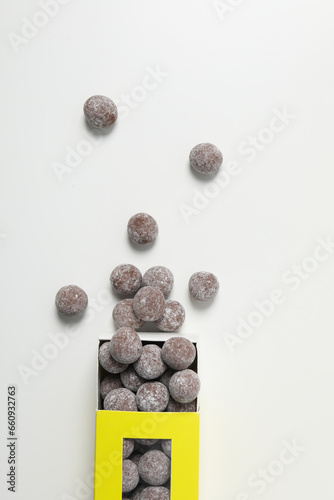 Chocolate candies in box on white background, top view