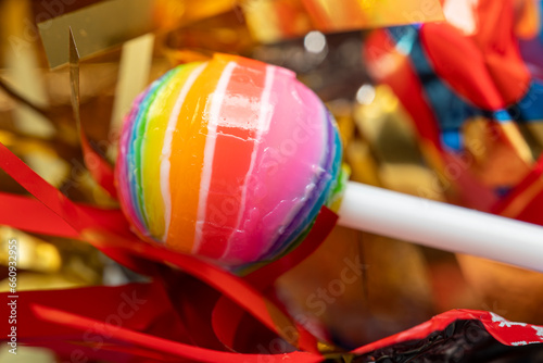 Rainbow colored round lollipop. Bright sweets for children. Multi-colored lollipop close-up.