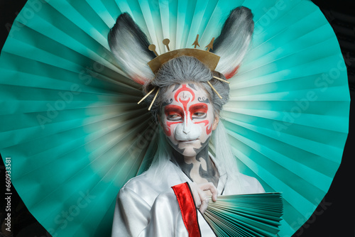 Colorful portrait of cute woman face in animal mask and creative makeup. Halloween  Carnival and Cosplay concept