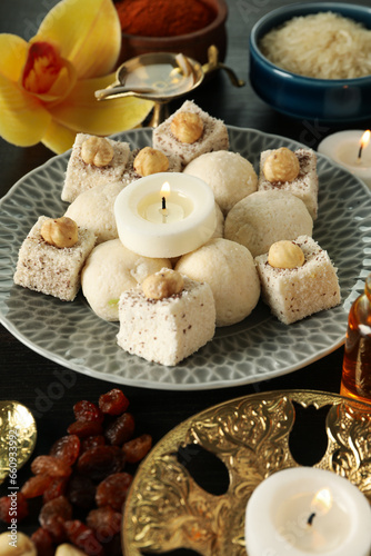 Sweets, candles and copper utensils on dark wooden background, close up