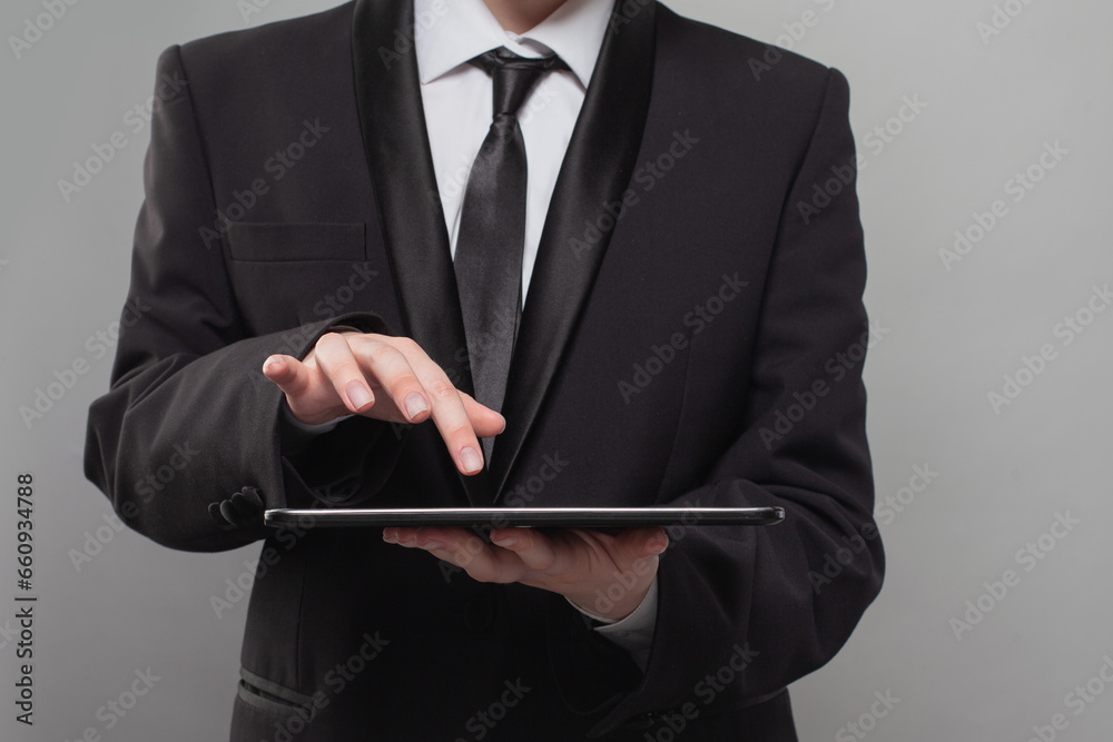 Business person using digital tablet closeup on gray background Business person using digital tablet closeup on gray background