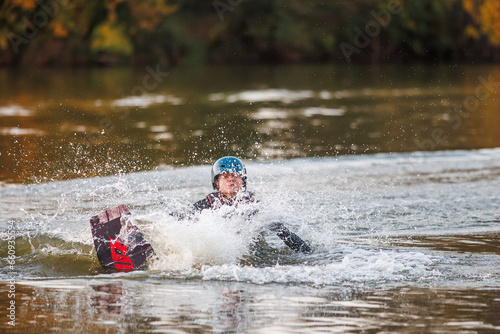 Girl on a wakeboard. An athlete performs a trick on the water. Autumn Park