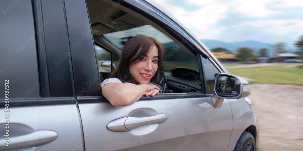 Young smiling woman park the car to car before trip and smiling at camera Young smiling woman park the car to car before trip and smiling at camera