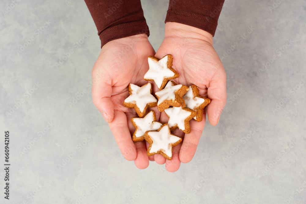 Obraz premium Cinnamon stars, Zimtsterne traditional german christmas cookies in the hands, gingerbread with anise spice for holidays 