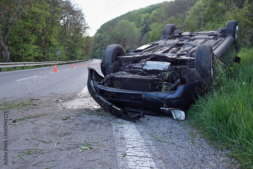Car accident. An overturned car lying upside down on the street after an accident. The car crashed on the road and overturned. Real event. 