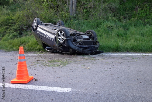 Car accident. An overturned car lying upside down on the street after an accident. The car crashed on the road and overturned. Real event. 