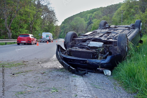 Car accident. An overturned car lying upside down on the street after an accident. The car crashed on the road and overturned. Real event. 