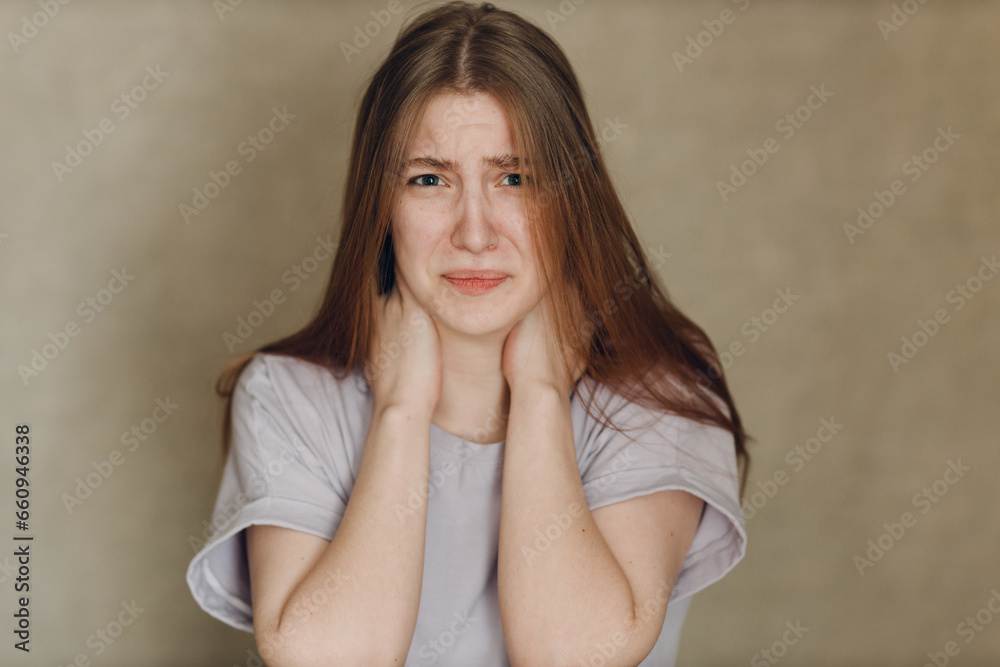 Portrait of young sad upset caucasian woman looking at camera against beige background. Casting film movie acting auditions. Portrait of young sad upset caucasian woman looking at camera against beige background. Casting film movie acting auditions.