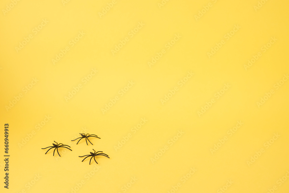 Yellow background with spiders at the bottom as if they were walking. copy space. Halloween