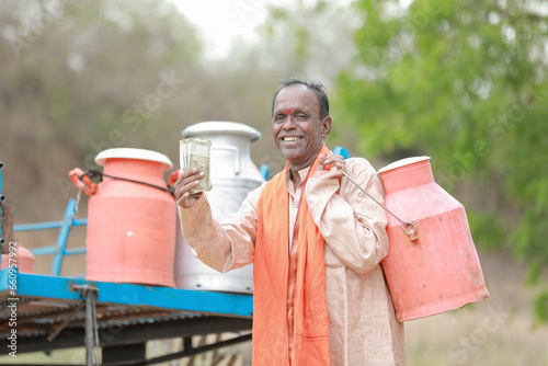 happy Indian farmer selling milk in farm