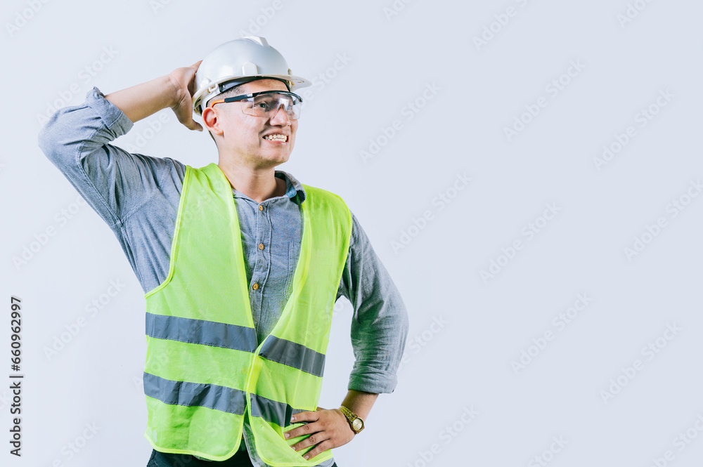 Worried builder engineer holding his head isolated. Troubled young engineer holding his head looking up. Worried male engineer man holding his head Worried builder engineer holding his head isolated. Troubled young engineer holding his head looking up. Worried male engineer man holding his head